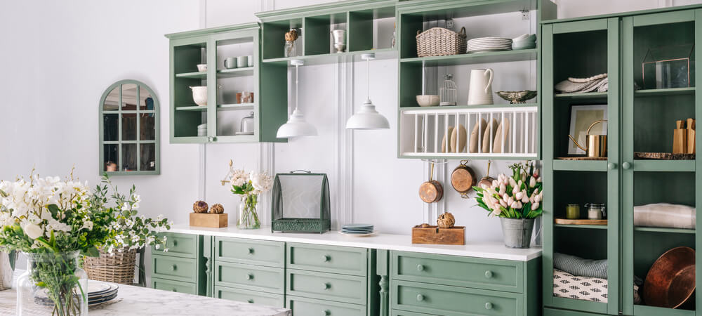 Kitchen with Sage green base cabinets paired with wood flooring and brass accents